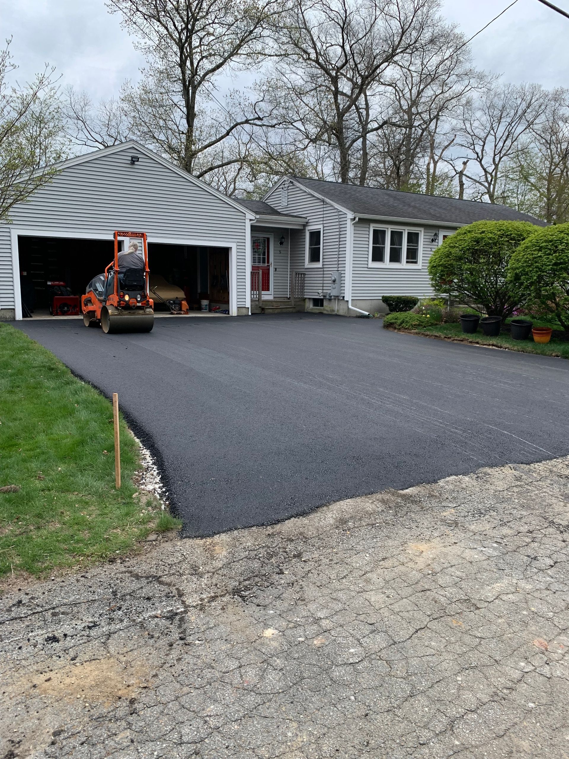 A driveway is being paved in front of a house.
