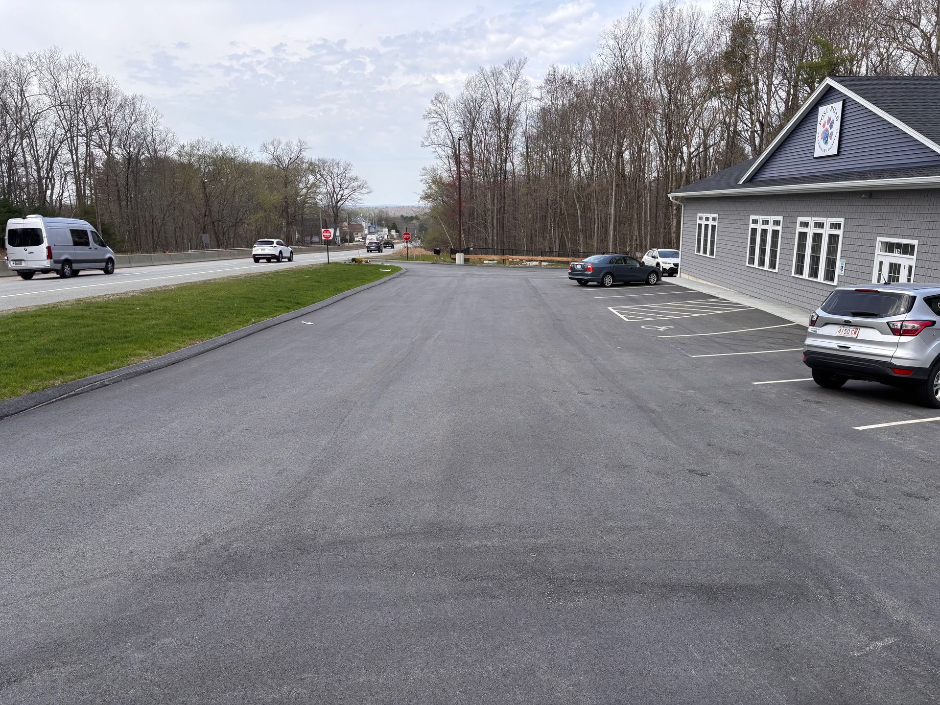 A parking lot with cars parked in front of a building.
