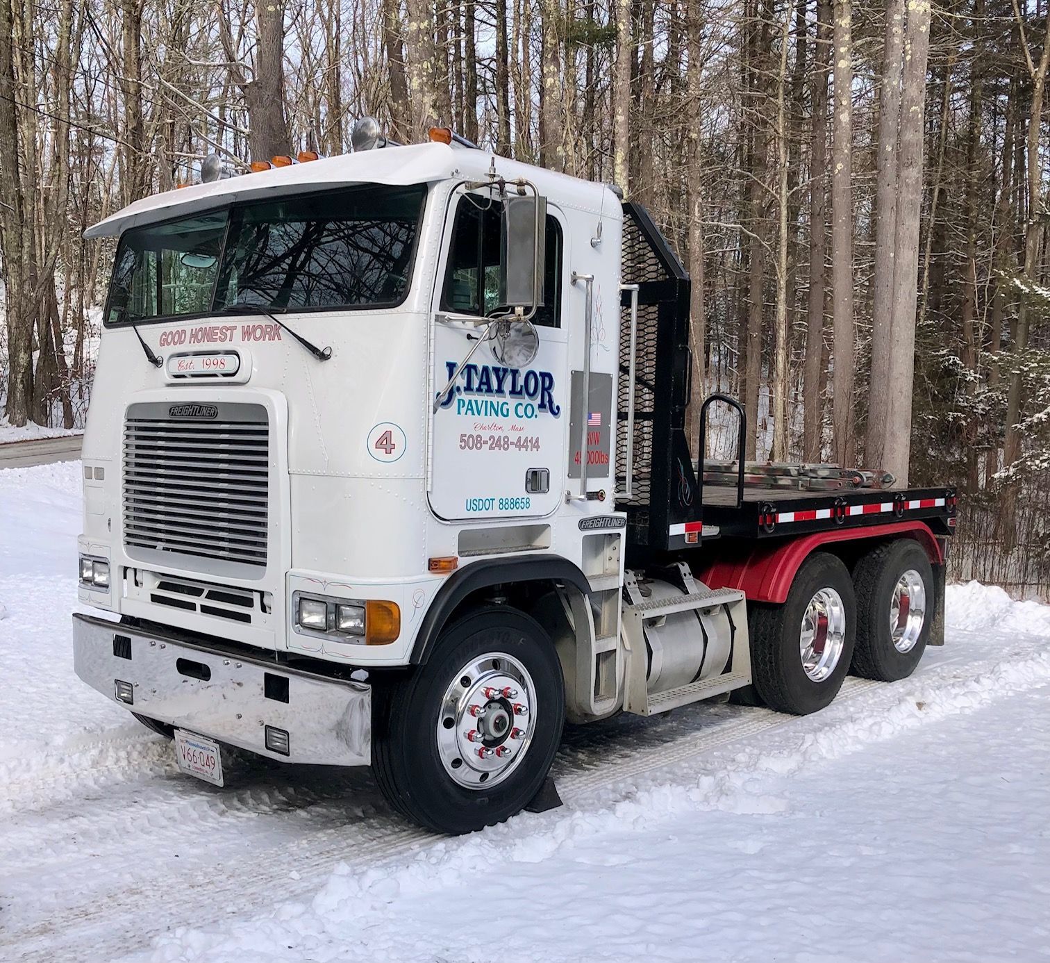 A white taylor truck is parked in the snow.