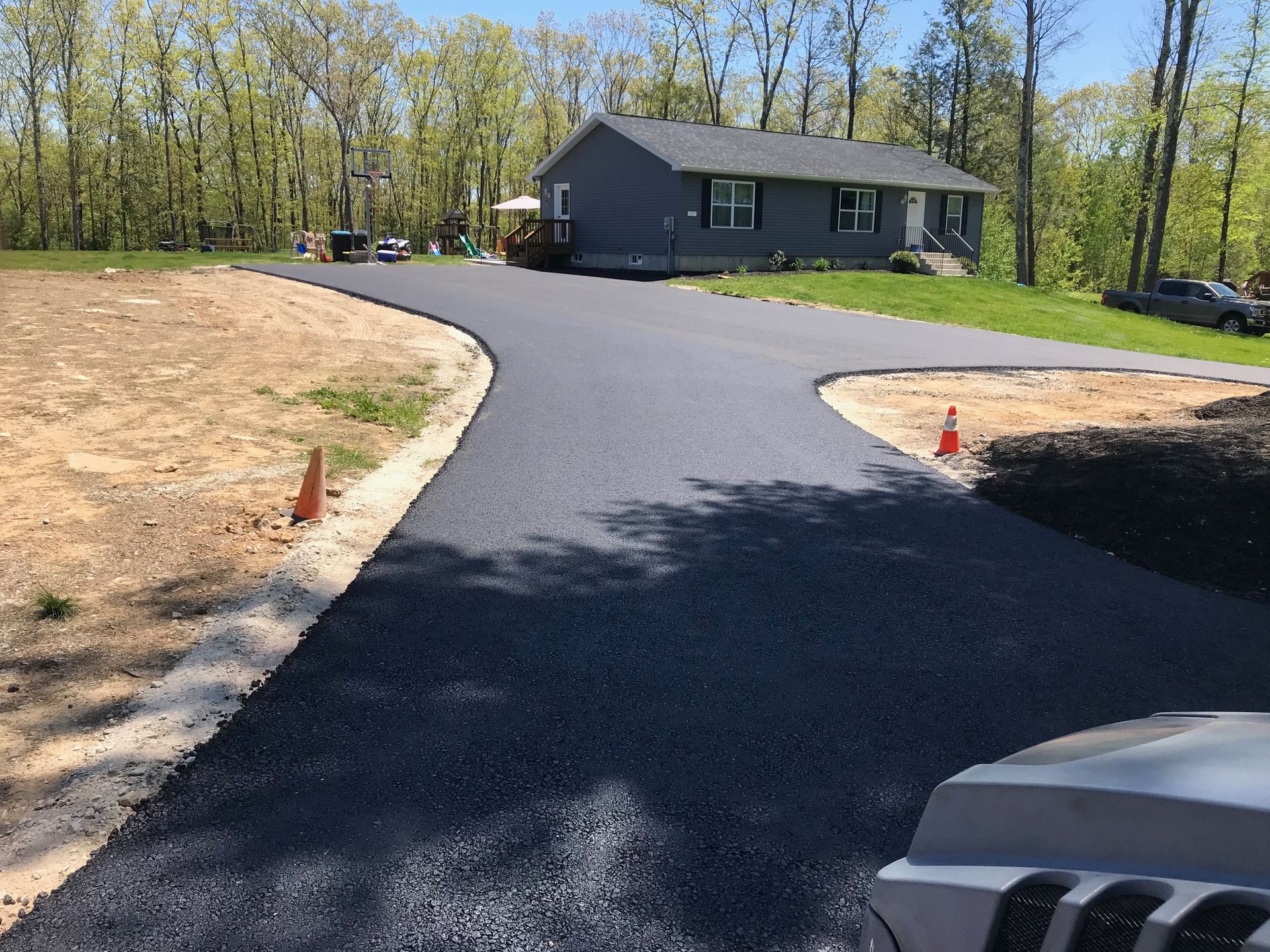 A jeep is parked on the side of a road next to a house.