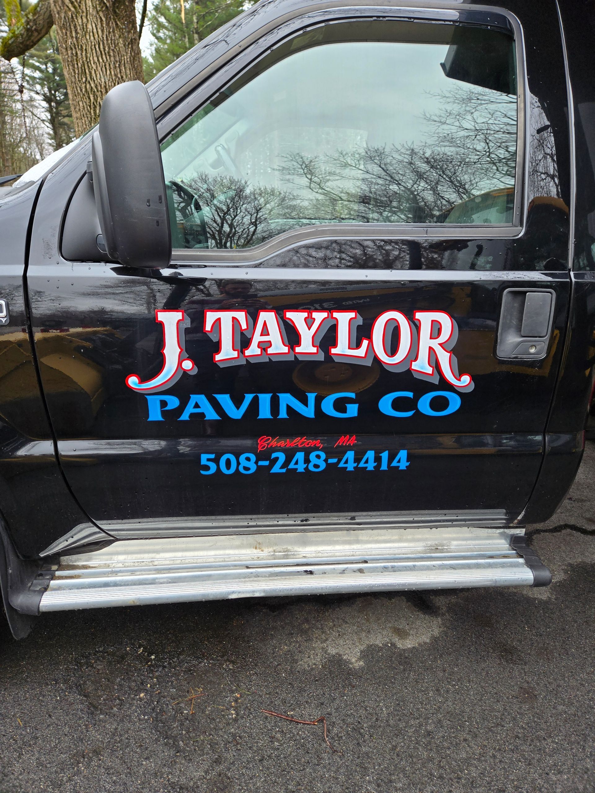 A black truck with j. taylor paving co written on the side.