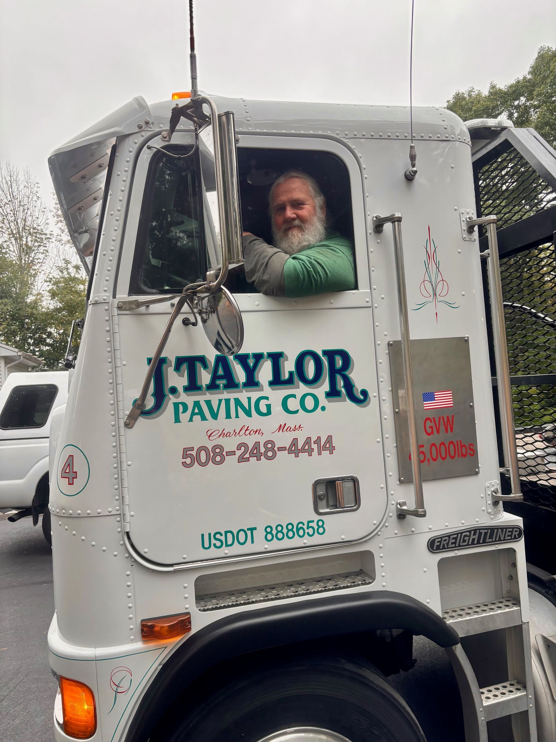 A man is sitting in the driver 's seat of a truck.