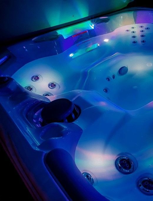 Couple relaxing in a hot tub on a deck with autumn foliage, 