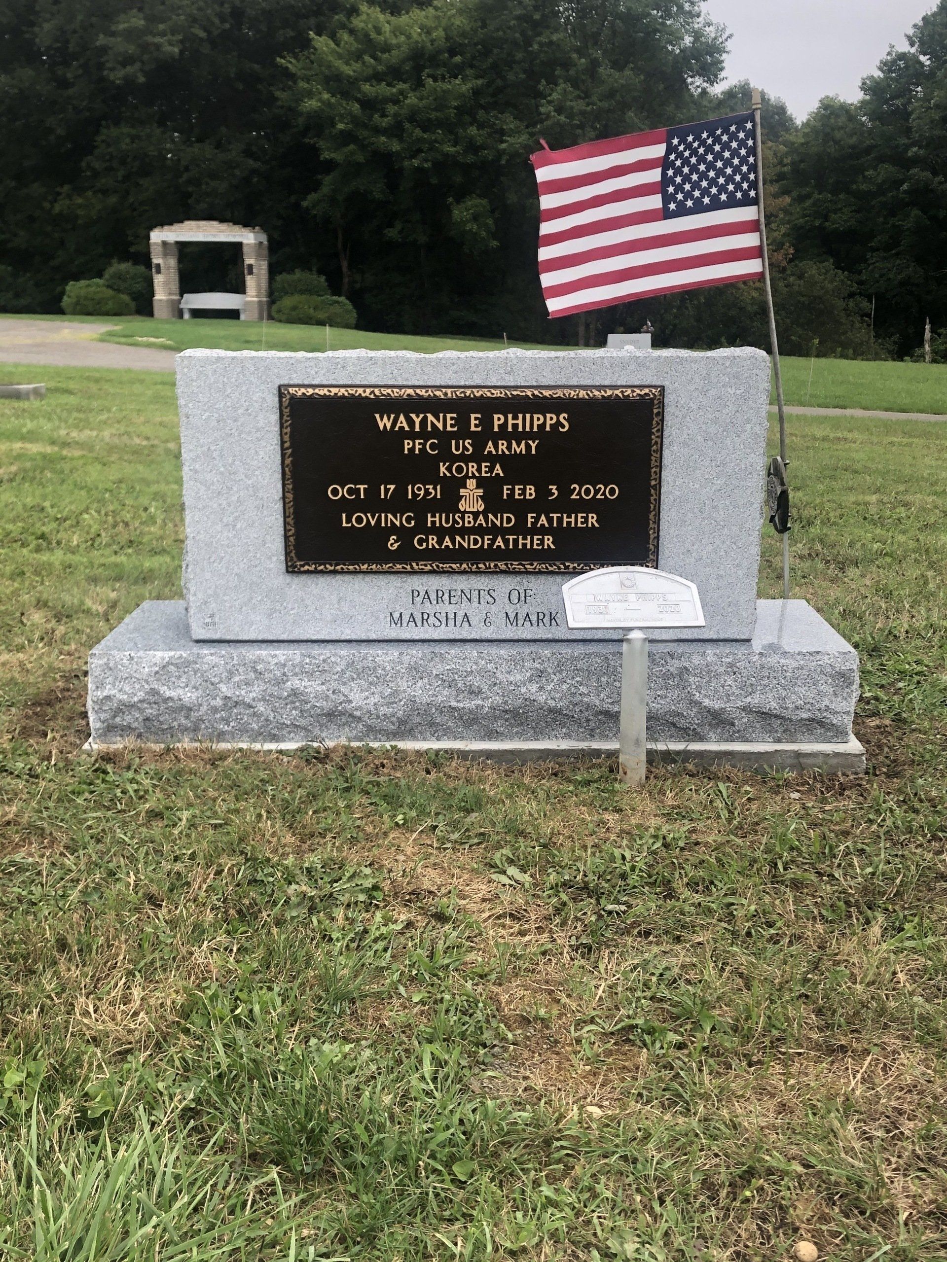 A gravestone in a cemetery with an american flag on it