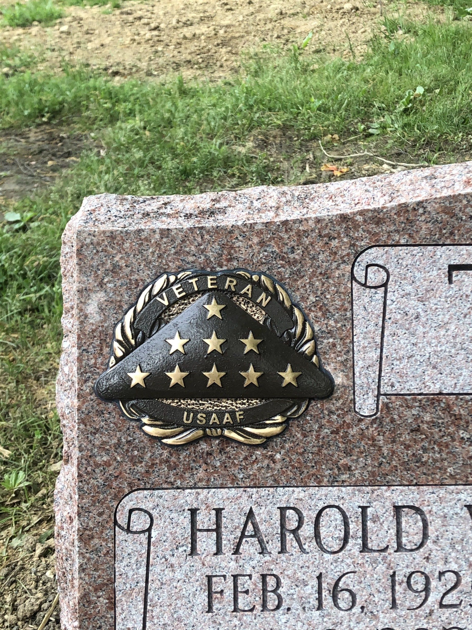 A gravestone for a veteran with a hat on it.