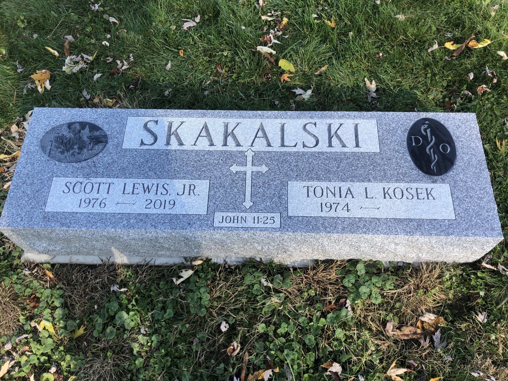 A grave in a cemetery with a cross on it.