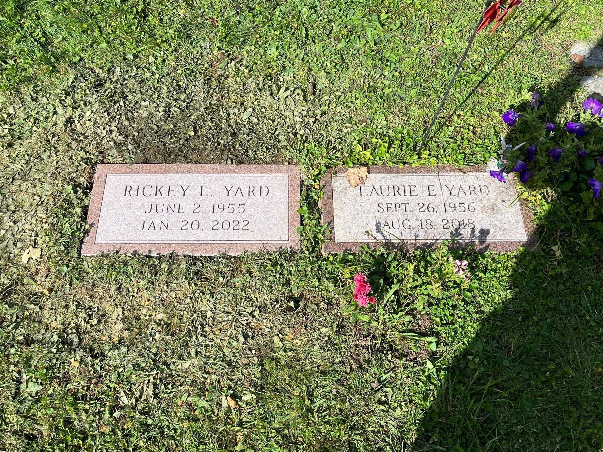 There are two graves in the grass in a cemetery.