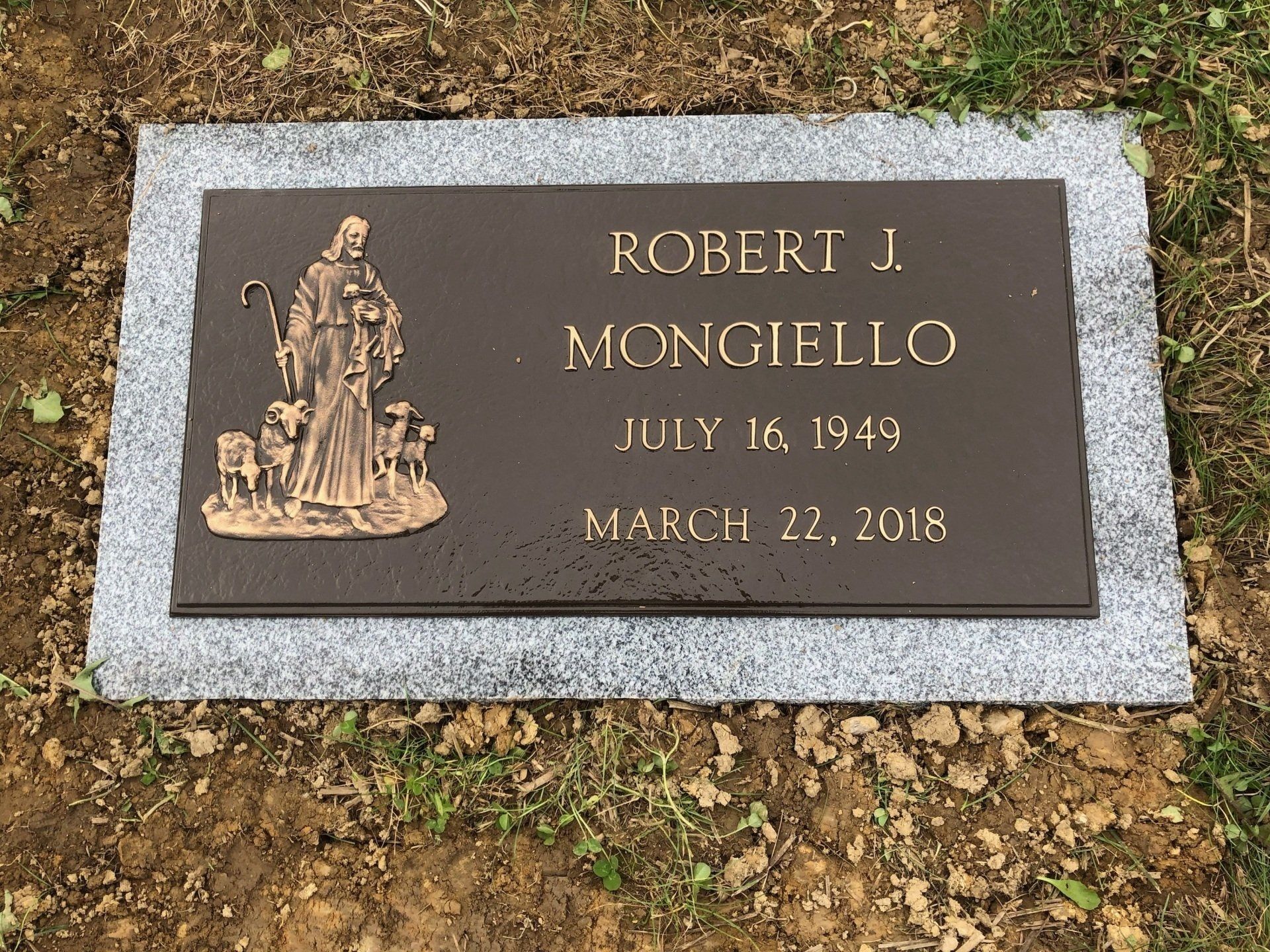 A gravestone for robert j. mongiello is in a graveyard.