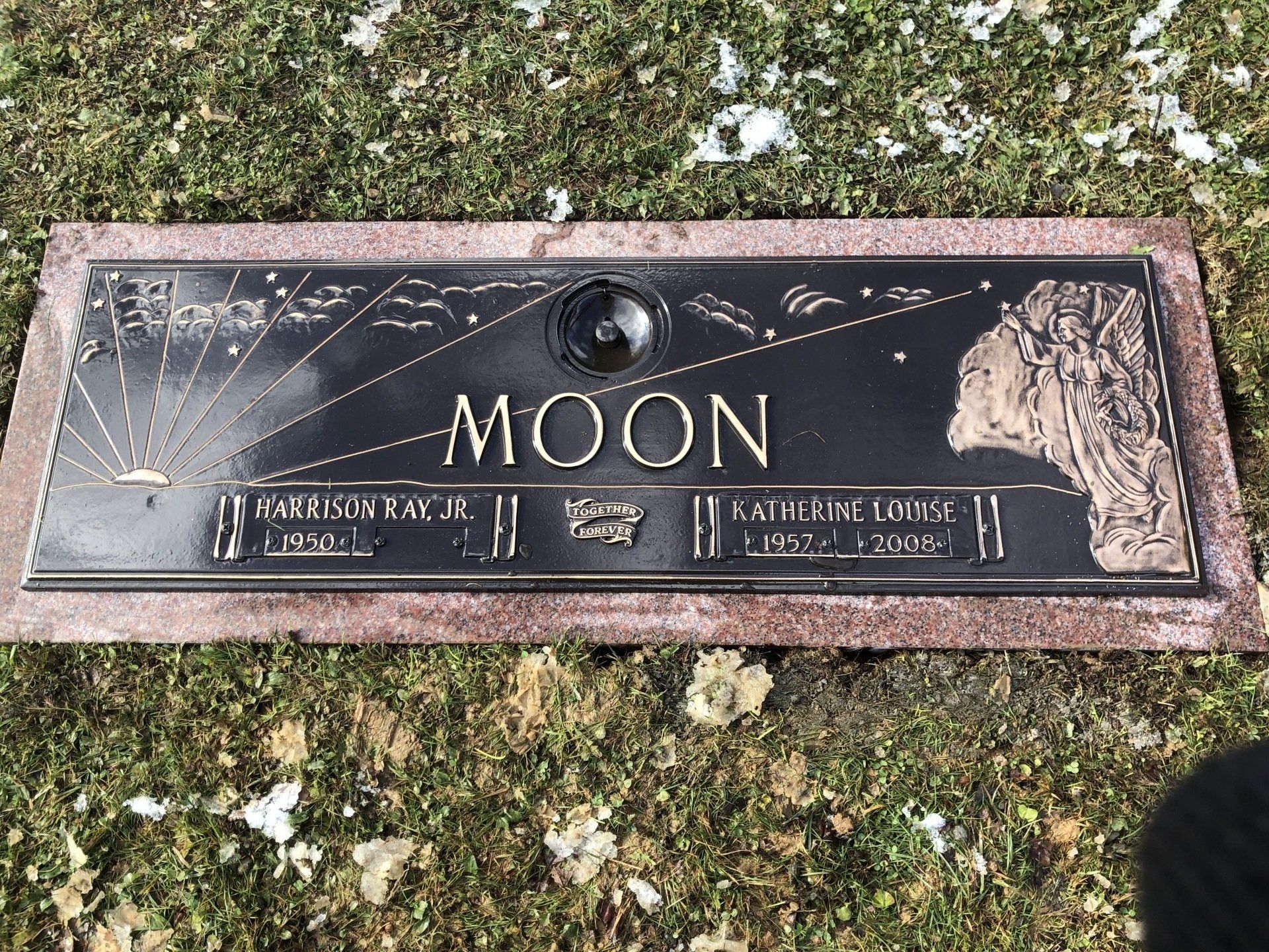A gravestone in a cemetery with the name moon on it.