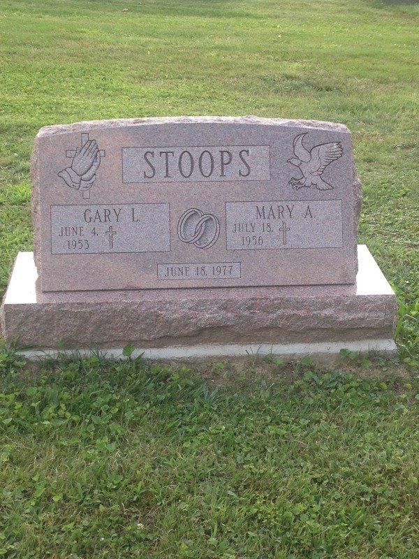 A gravestone for gary and mary stoops in a cemetery.