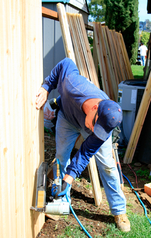 carpenter constructing a wooden fence