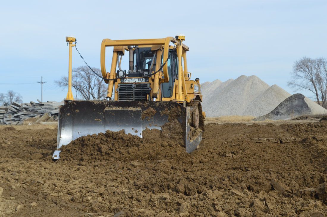 Yellow bulldozer pushing earth at a construction site.