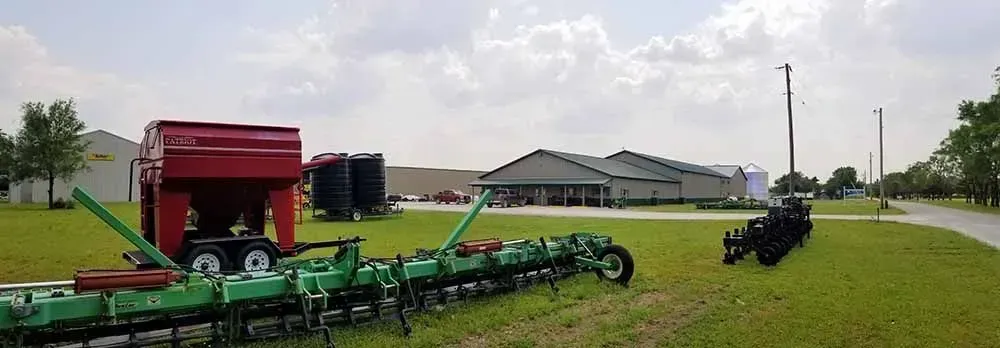 A tractor with a planter in a field, ready to sow seeds.