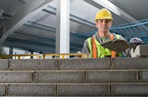 Contractor layering concrete blocks