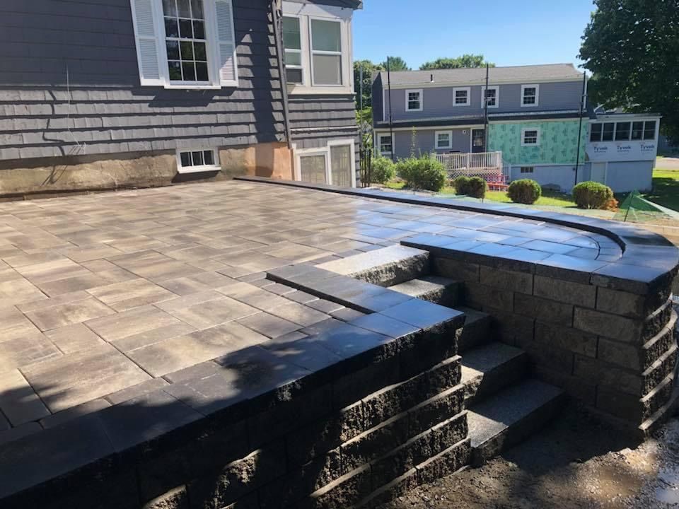 Backyard deck with worn wooden stairs and a small rooftop-style platform beside a house