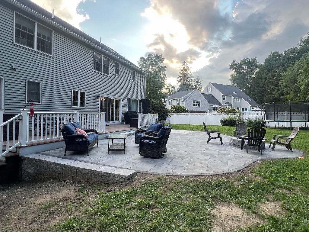 Patio with outdoor chairs and table beside a striped house at dusk
