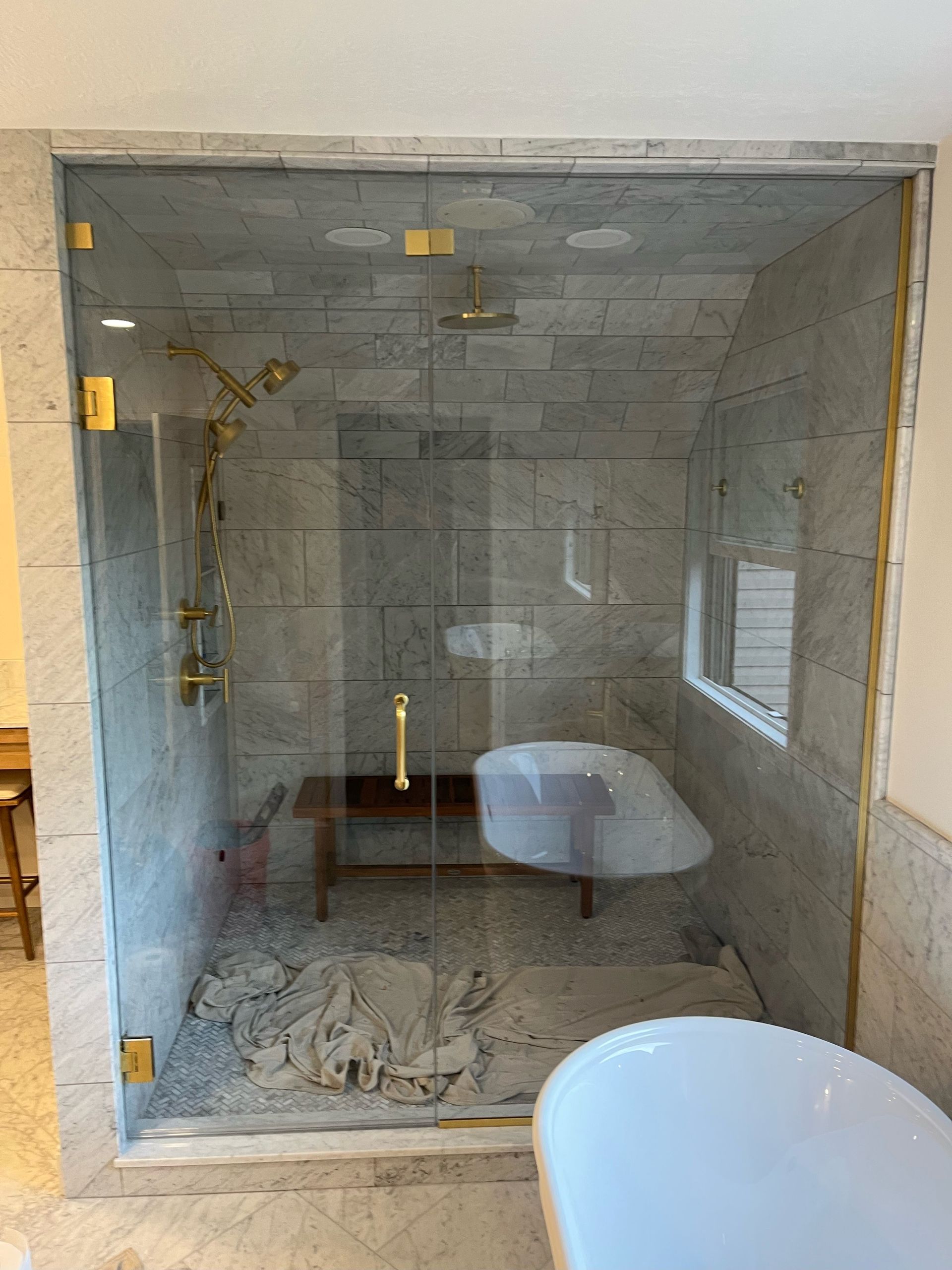 A bathroom with a bathtub and a shower stall with a glass door.