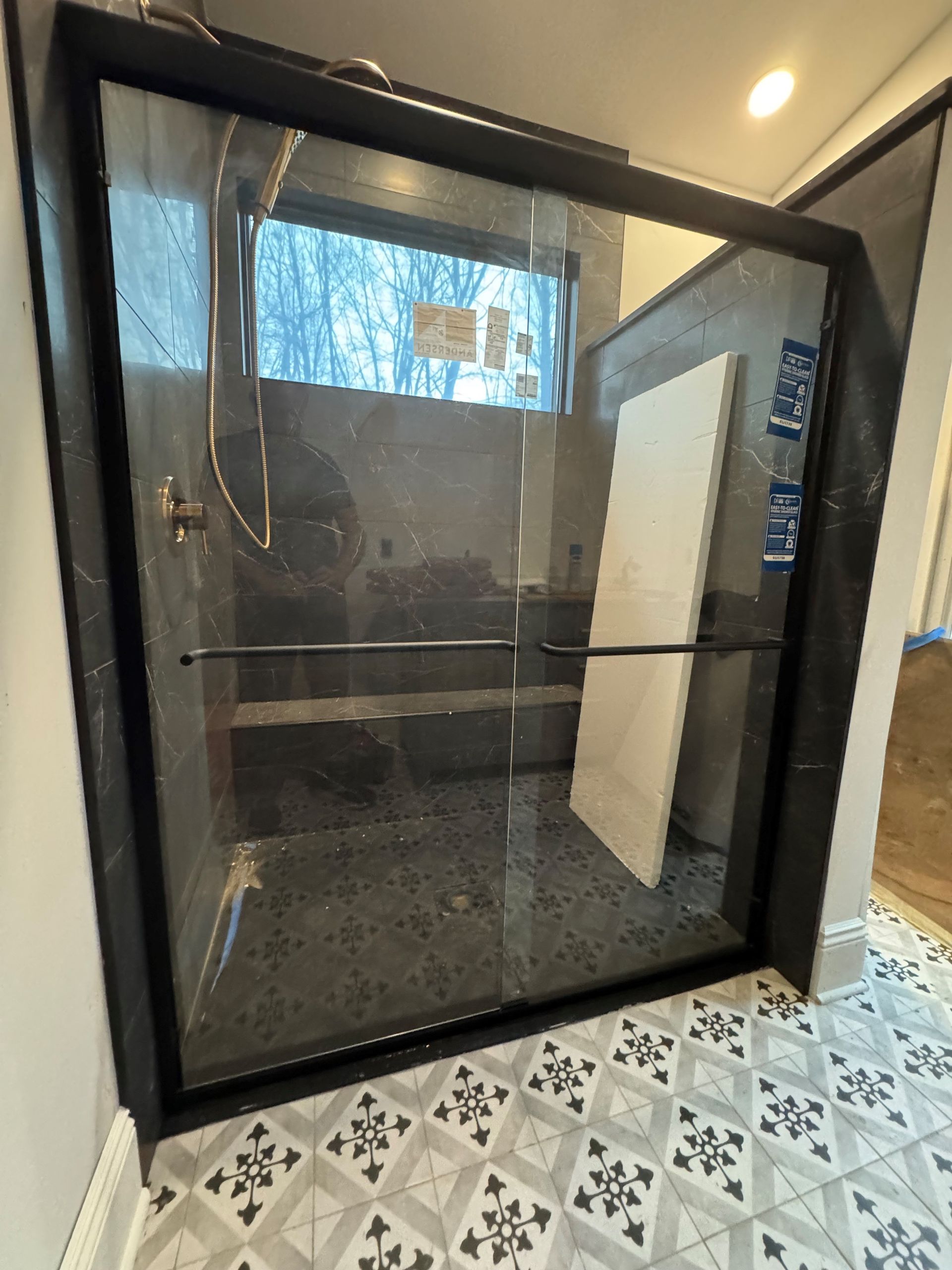 A bathroom with a walk in shower and a tiled floor