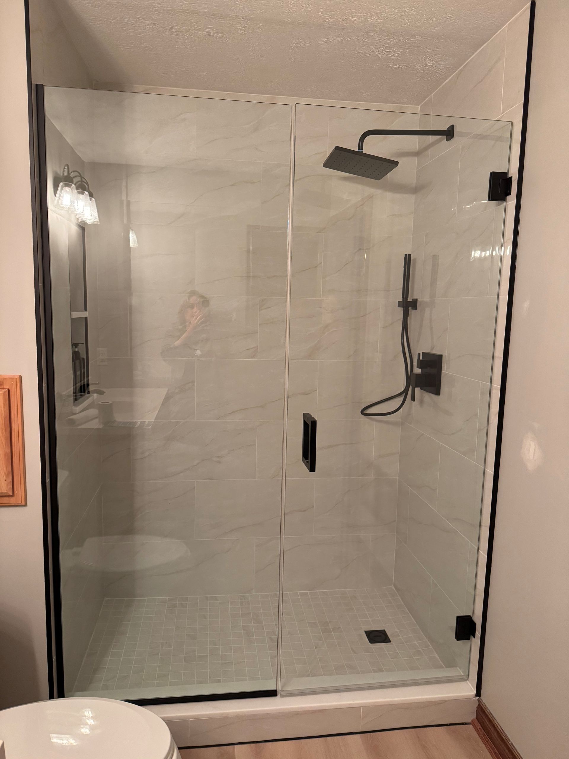 A bathroom with a walk in shower and a toilet