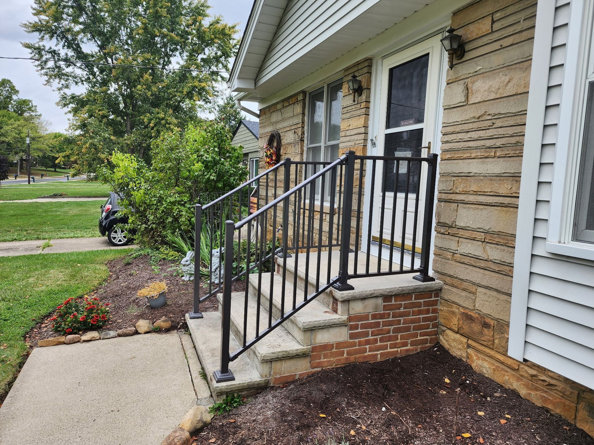 A house with stairs and a railing on the side of it.