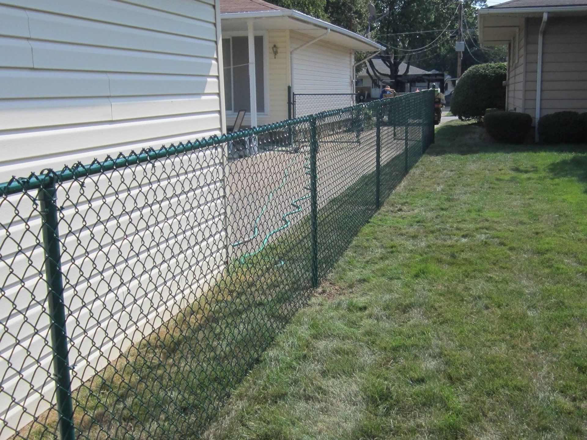 A chain link fence along the side of a house