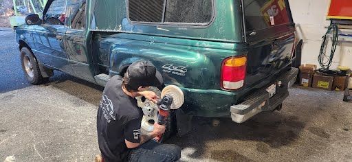 A person polishing a green truck.