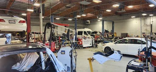 Inside a busy auto repair shop with vehicles on lifts and awaiting repair.