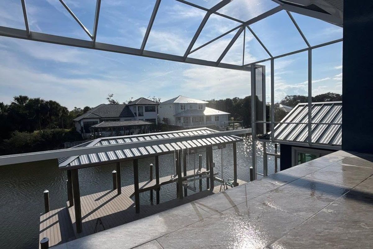 Sunlit rooftop terrace with metal pergola, tables, and a water view beyond neighboring buildings