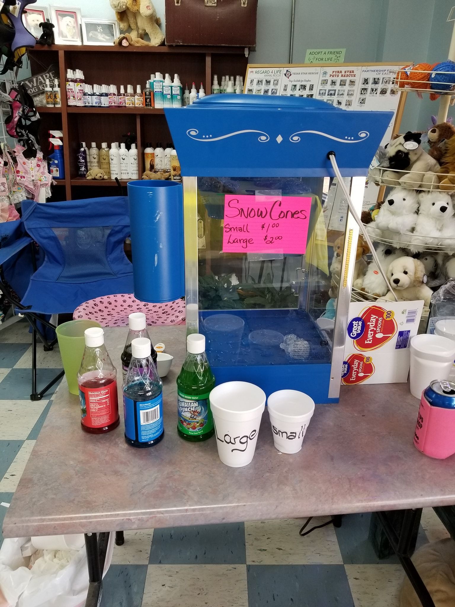A blue popcorn machine with a pink sign that says snow ice