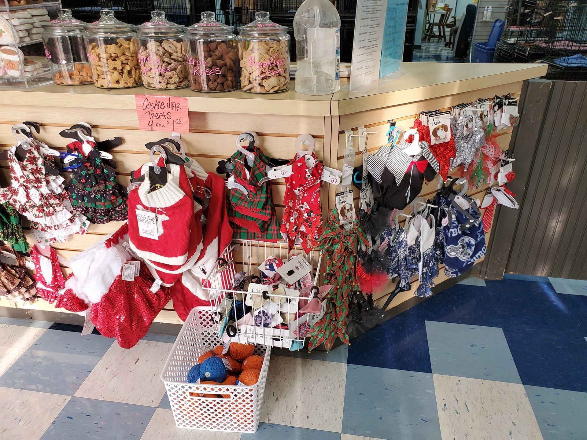 A display of christmas clothes for dogs in a store.