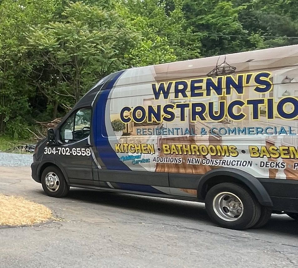 Wrenn's Construction van on a road with phone number. Residential and commercial services listed.