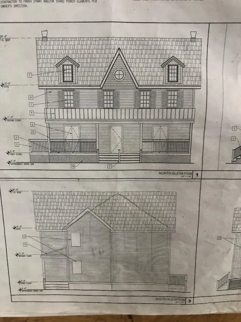 Architectural drawings of a two-story building. Front view shows a shop with a porch. Side view shows a gable roof.
