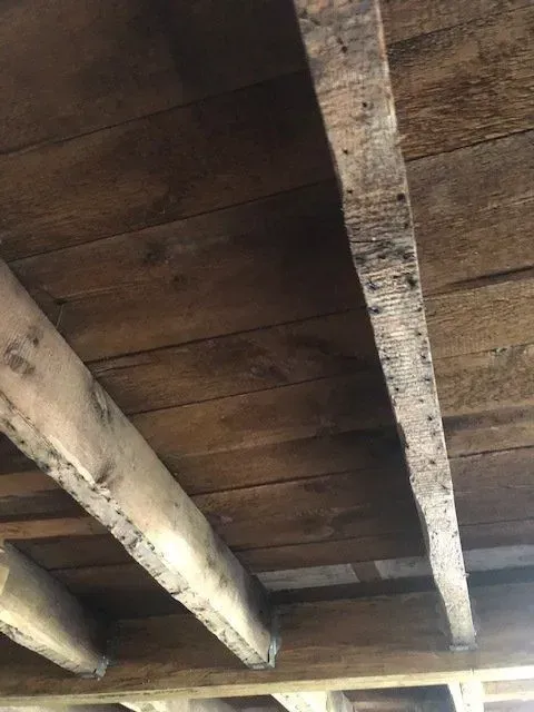 Wooden ceiling with exposed beams and dark brown planks.