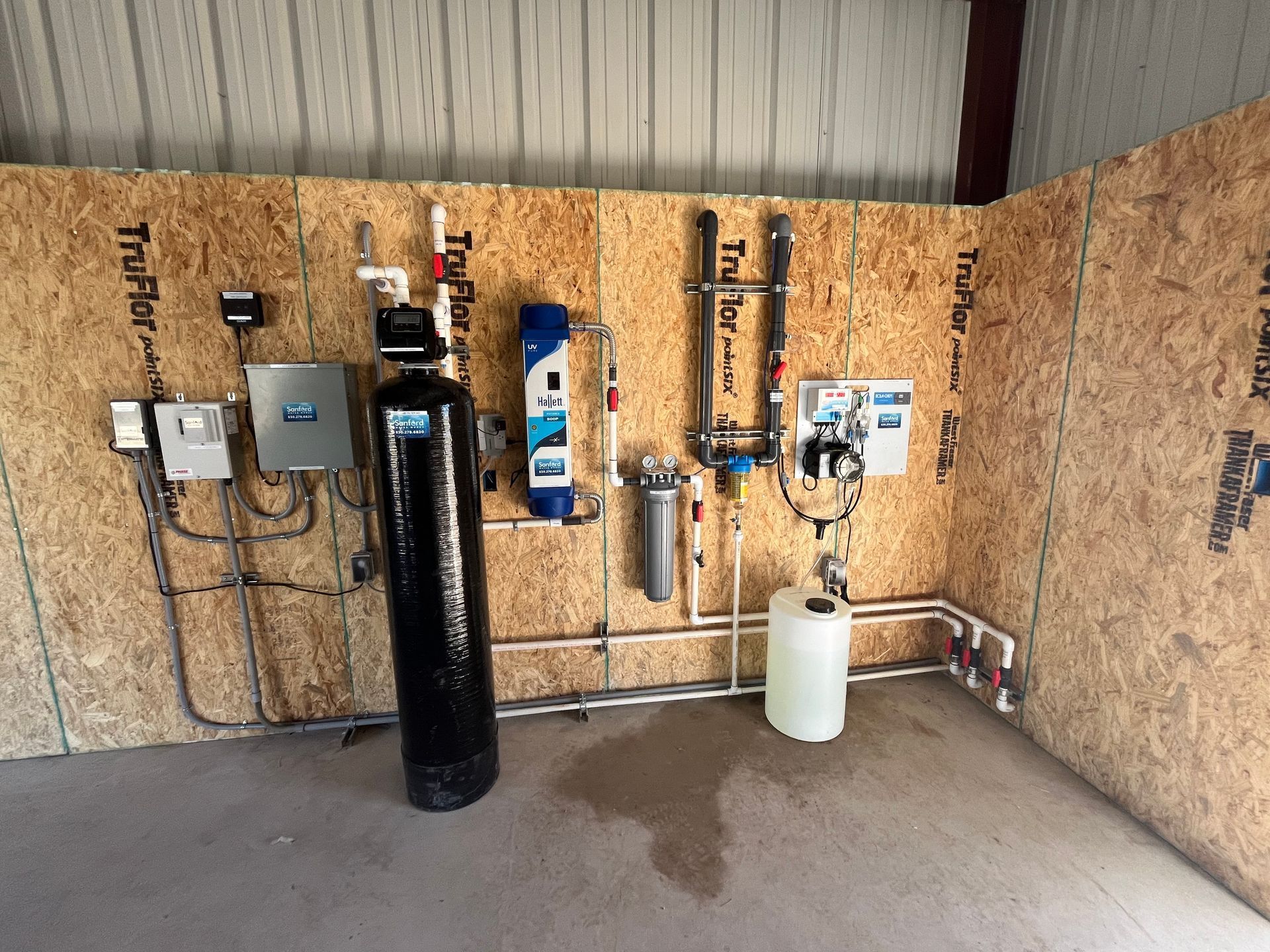 A room with a lot of pipes and a cylinder that says ' trifor ' on it