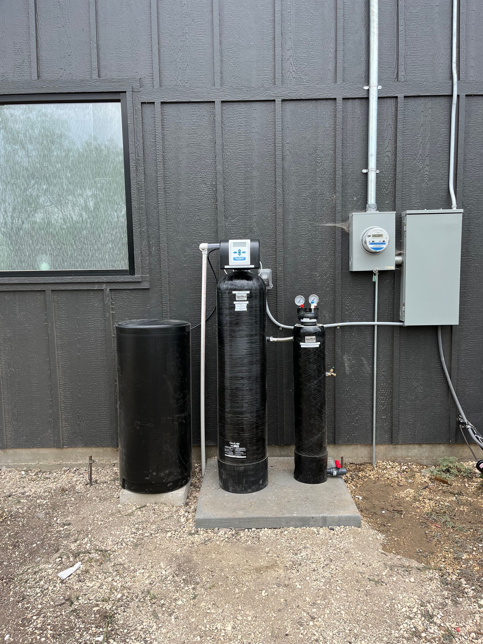 A water treatment system is installed on the side of a building.