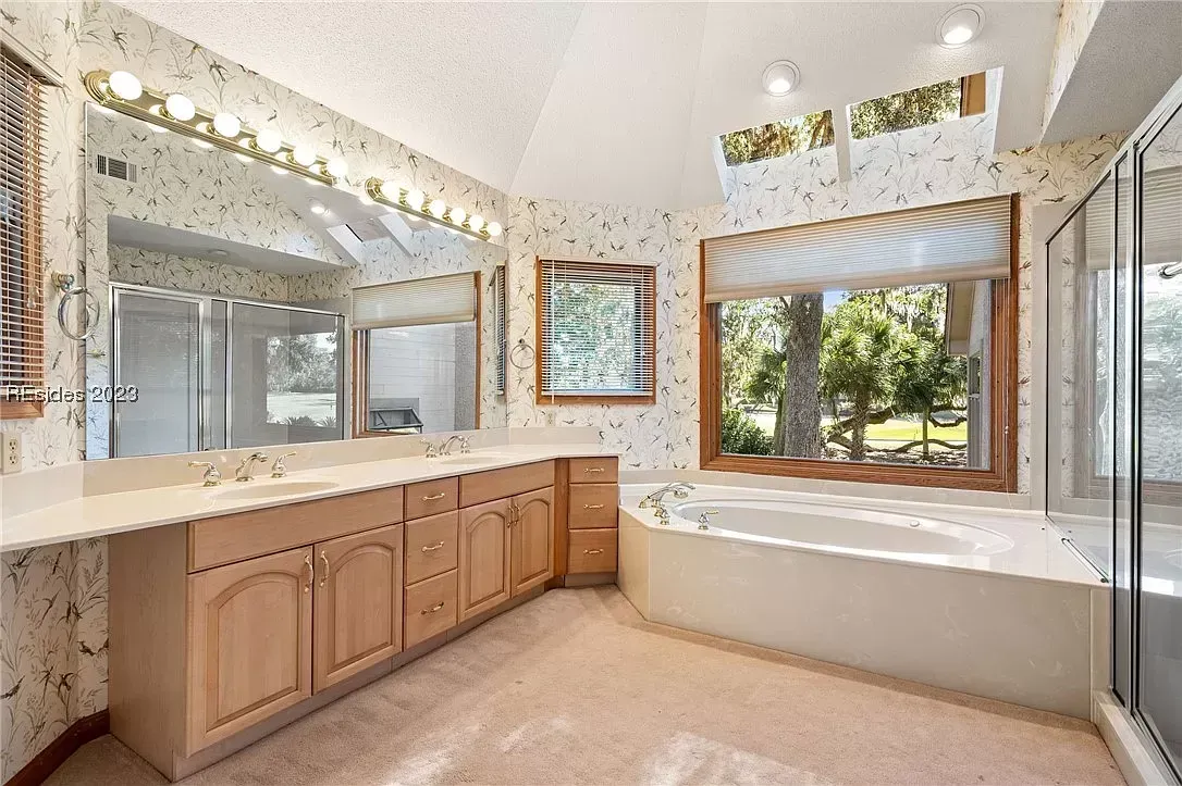 6 Planters - Before: Bathroom with vanity, large mirror, bathtub by window, and shower enclosure.