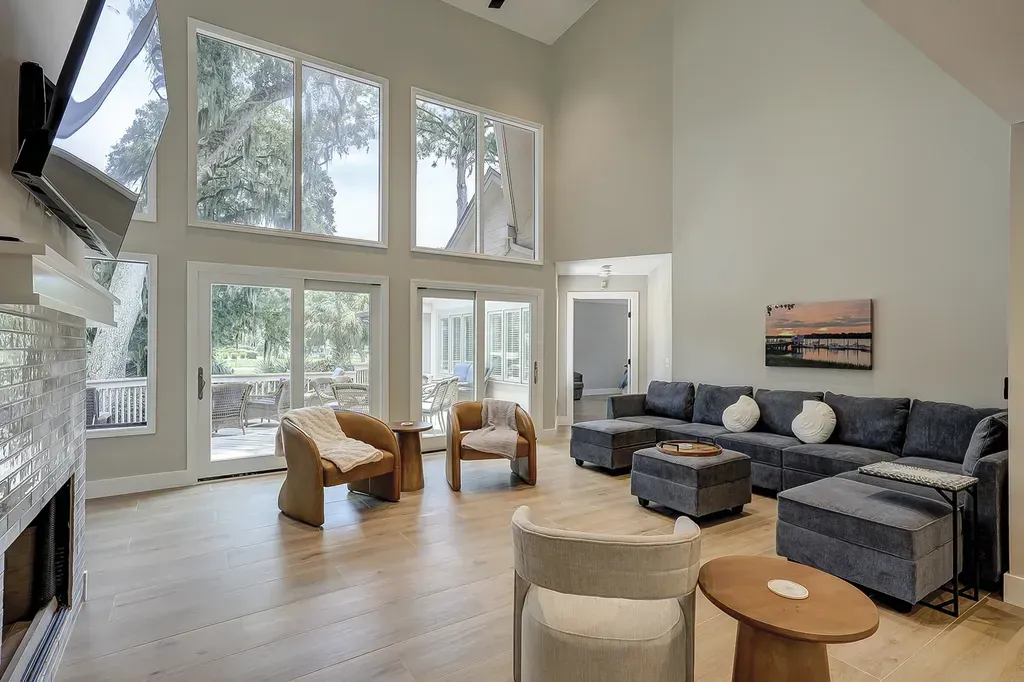 6 Planters - After: Spacious living room with large windows, light wood floors, and a blue sectional sofa.