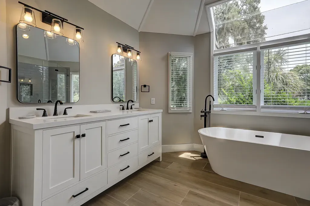 6 Planters - After: Bathroom with white vanity, double sinks, and a freestanding bathtub by a large window.