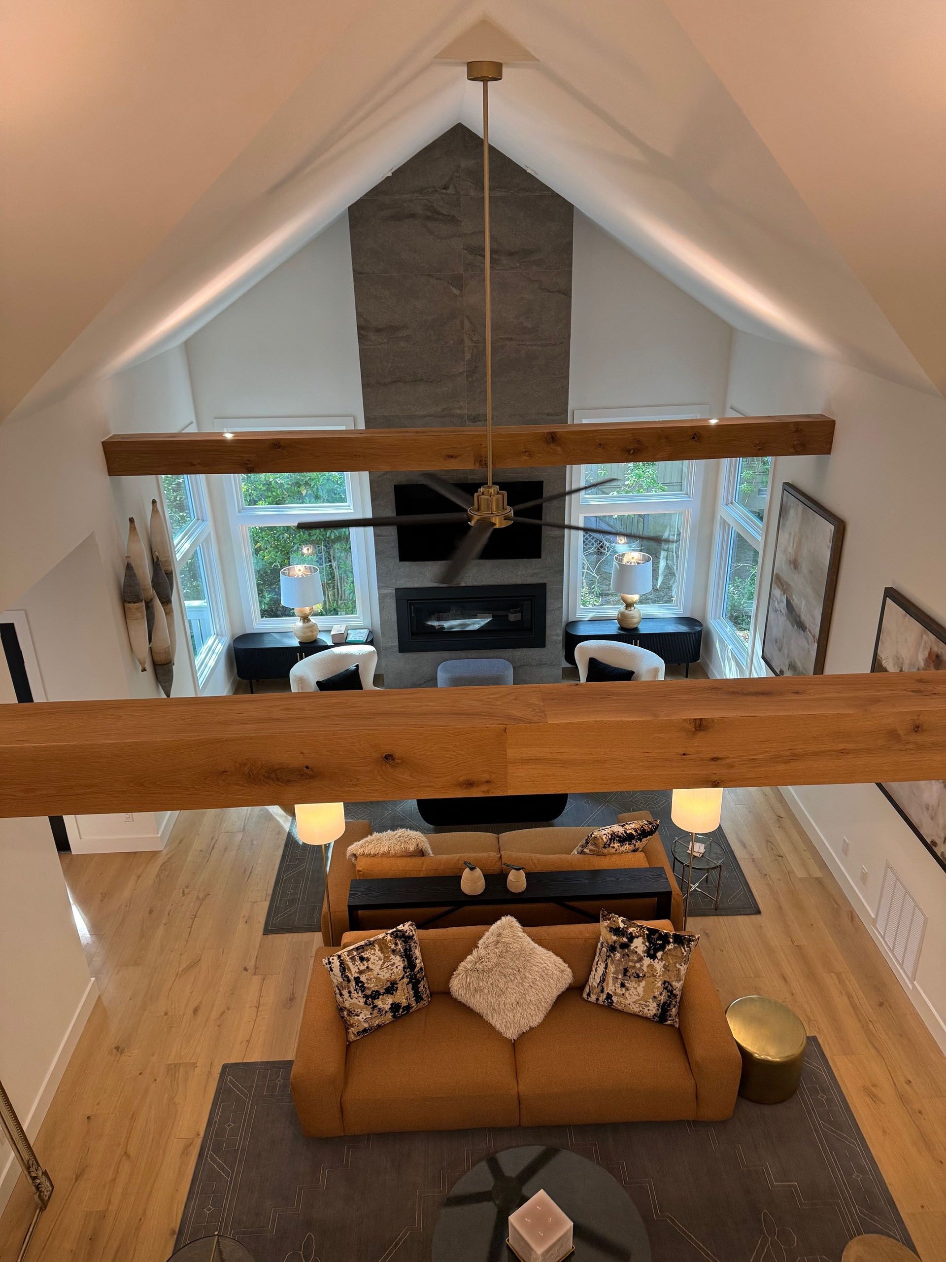 (18 Ensis) Port Royal Full Home Renovation: Living room with vaulted ceiling, fireplace, and exposed beams; brown sofa, neutral tones.