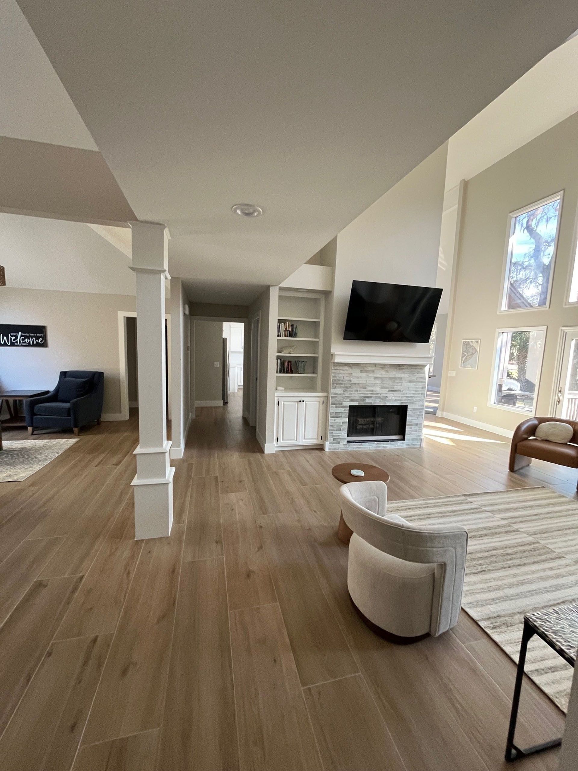 6 Planters - After: Spacious living room with fireplace, built-ins, and high ceilings.  Light-colored wood floors and neutral walls.