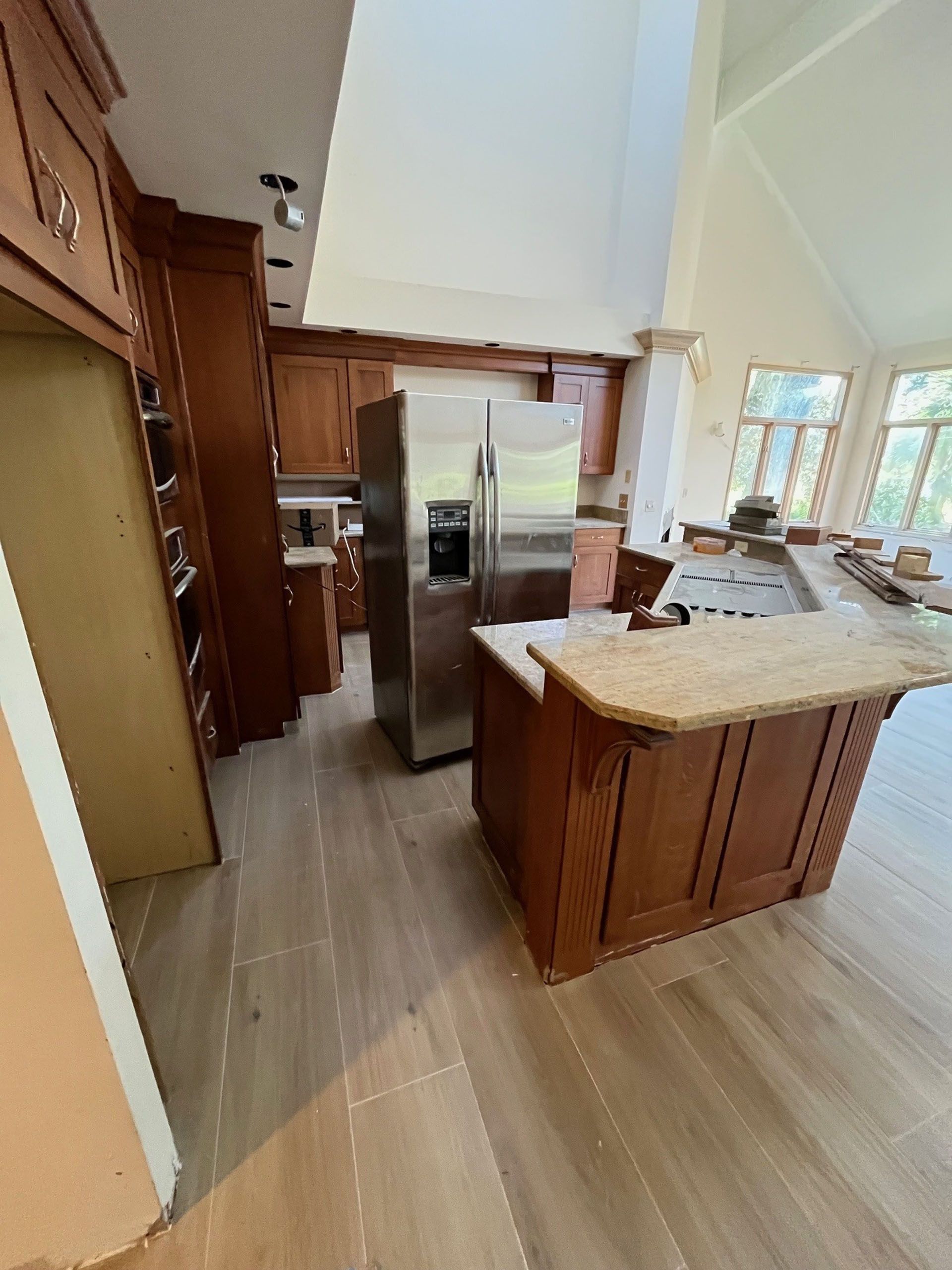 6 Planters - Before: Kitchen with stainless steel refrigerator, wooden cabinets, and a granite countertop island.