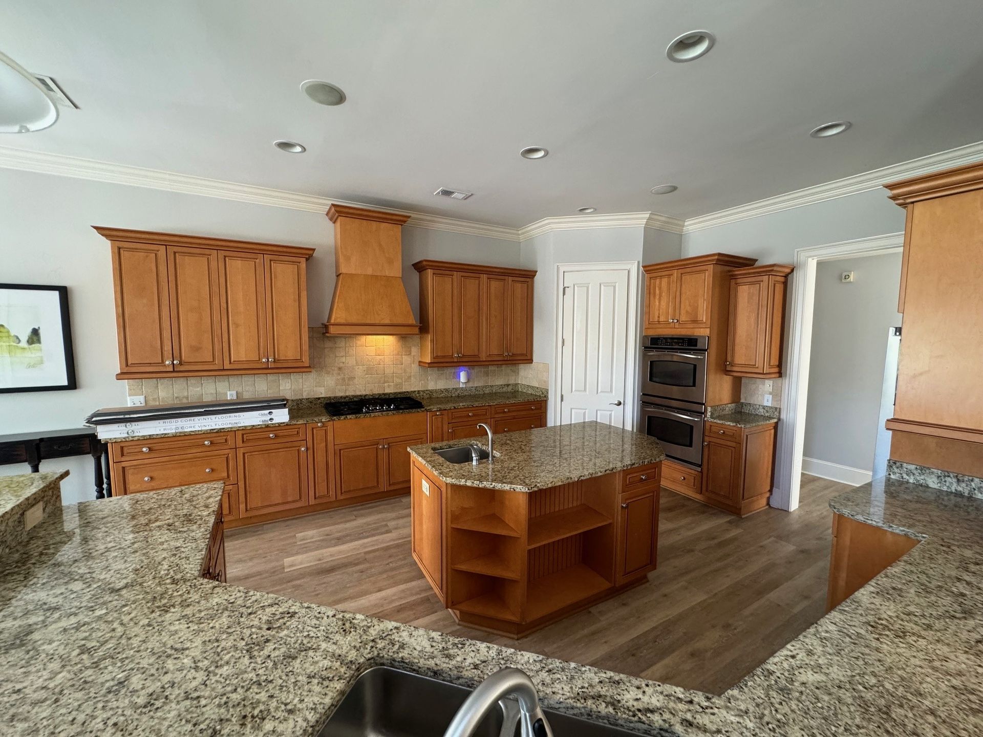 Spacious kitchen with wood cabinets, granite countertops, and a central island.