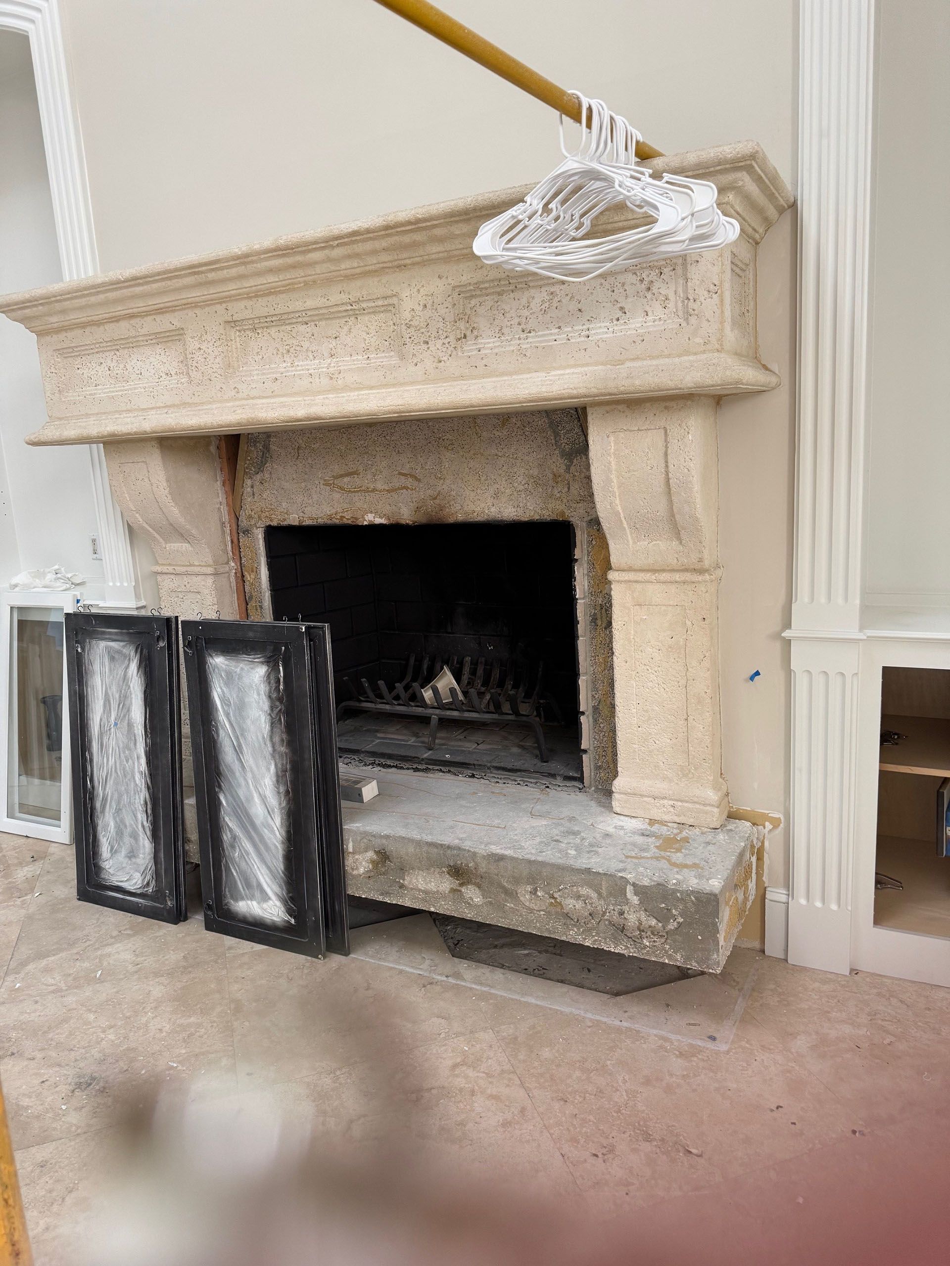Wexford Home Remodel - Before: Fireplace with mantel, two doors, and a cleaning tool. Interior setting.