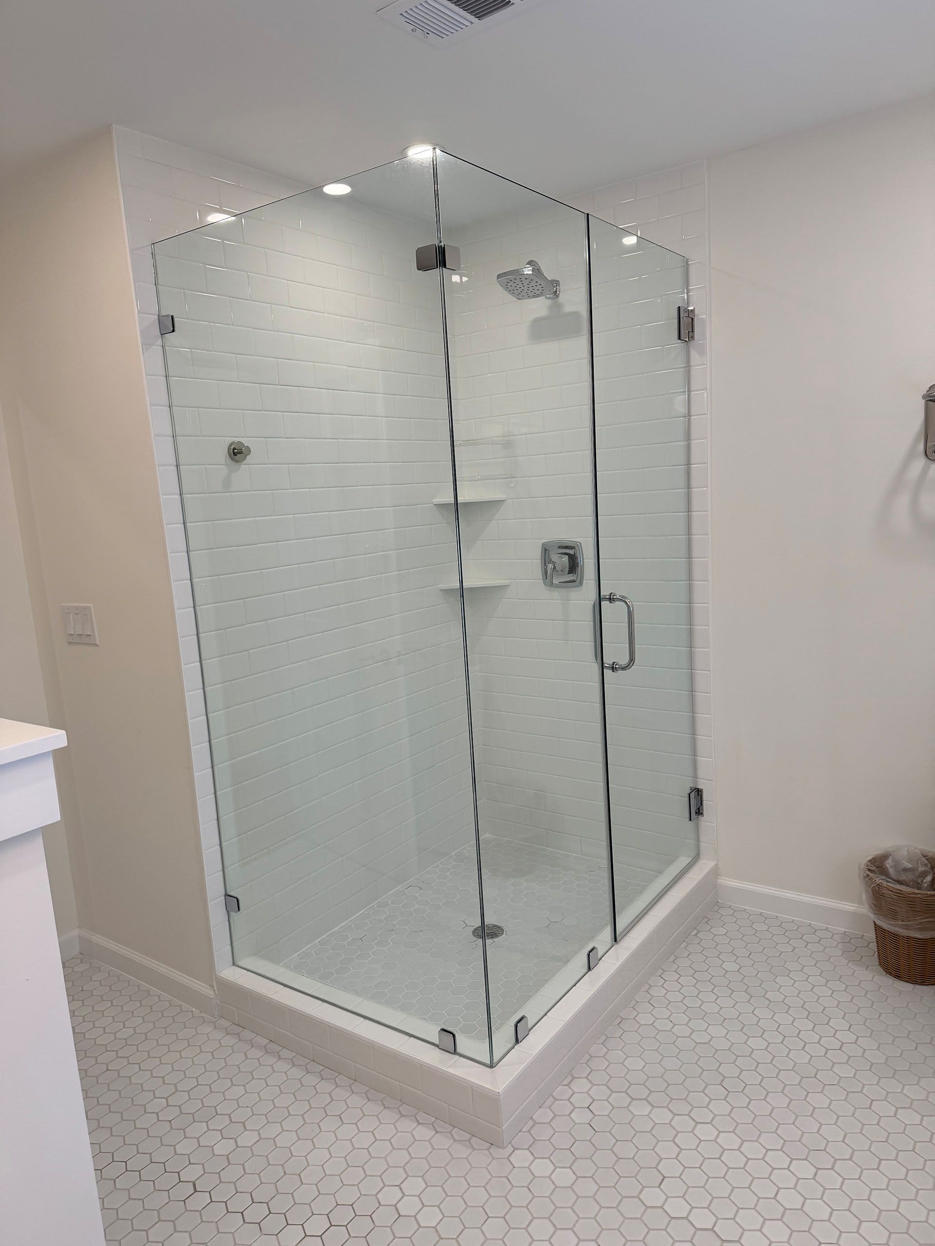 Miscellaneous Bathroom Projects - Glass corner shower with white tiled walls and floor, chrome fixtures.
