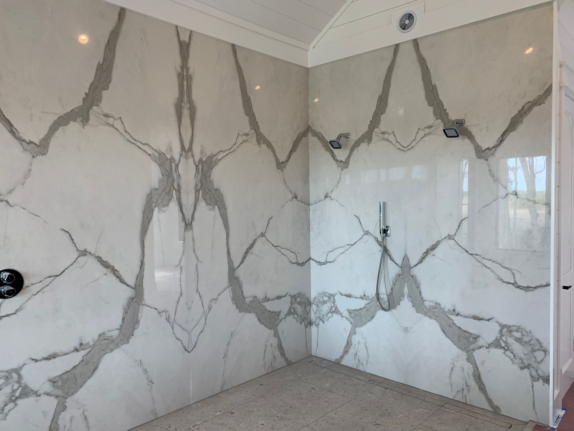 White bathroom with mirrored gray veined marble walls.
