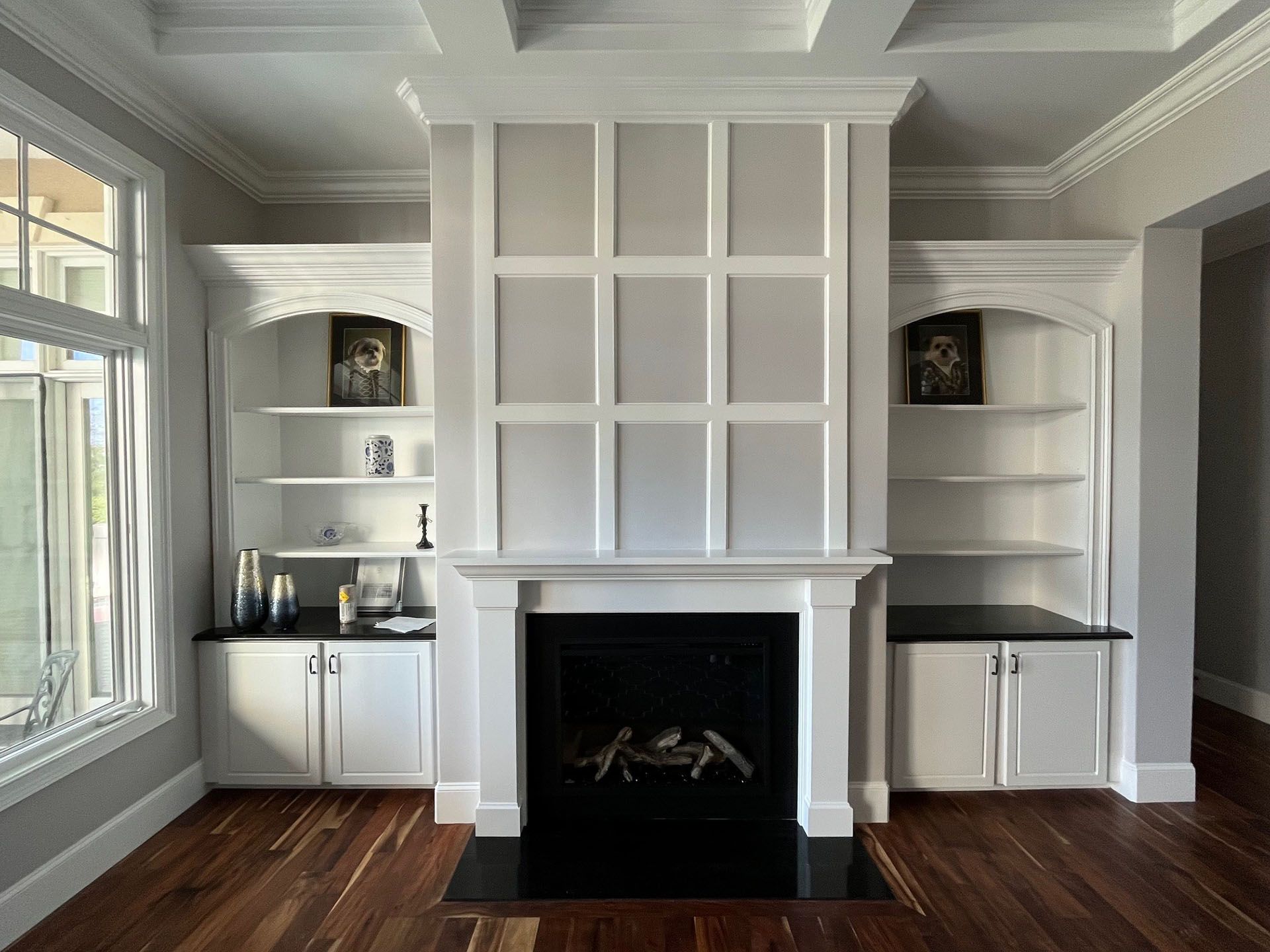 Miscellaneous Fireplace Projects - Fireplace with built-in bookshelves. White trim and cabinets, dark fireplace interior, and hardwood floors.