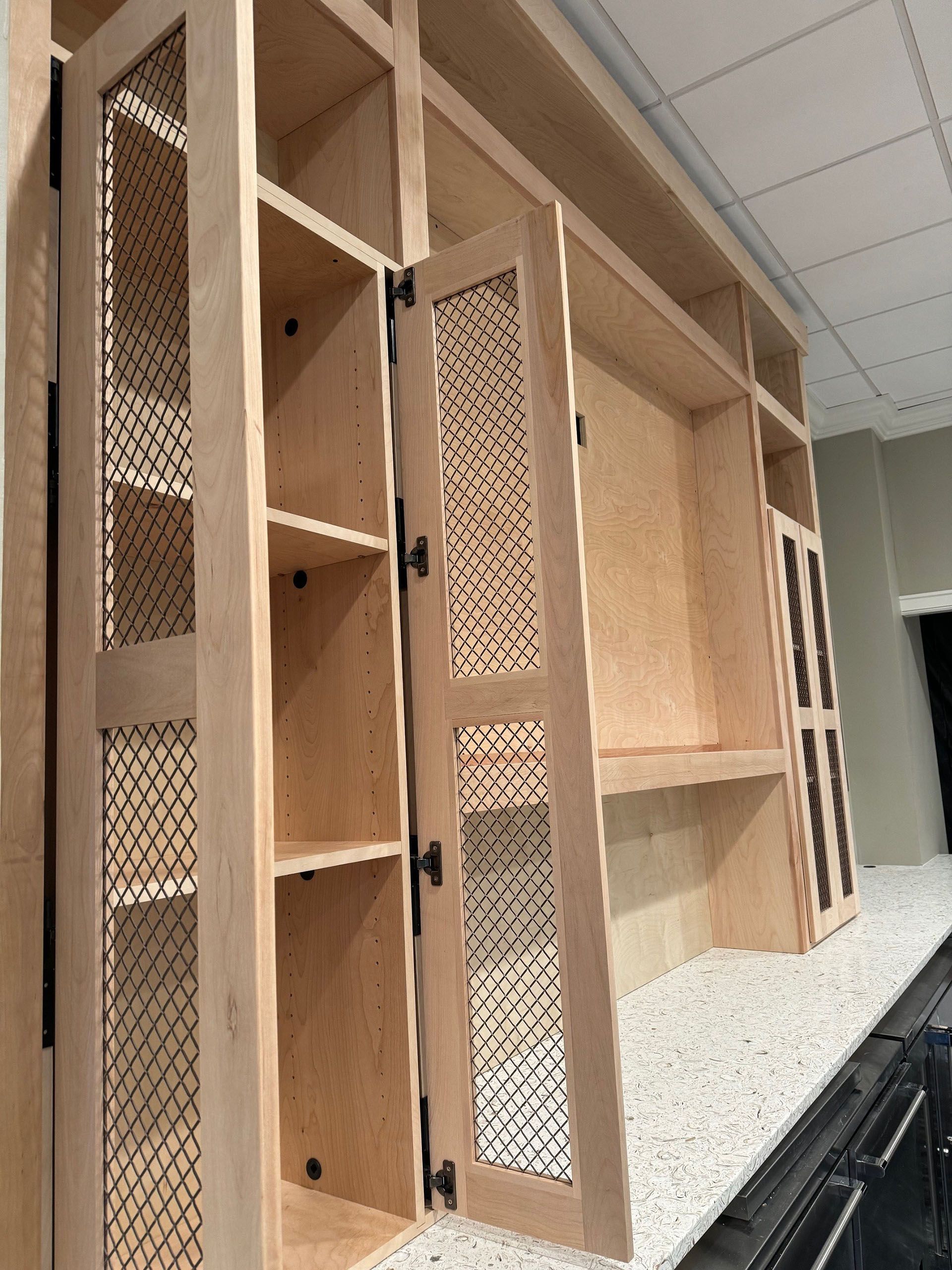 Miscellaneous Kitchen Projects - Light wood built-in cabinet with open shelving, a desk area, and doors with mesh panels.