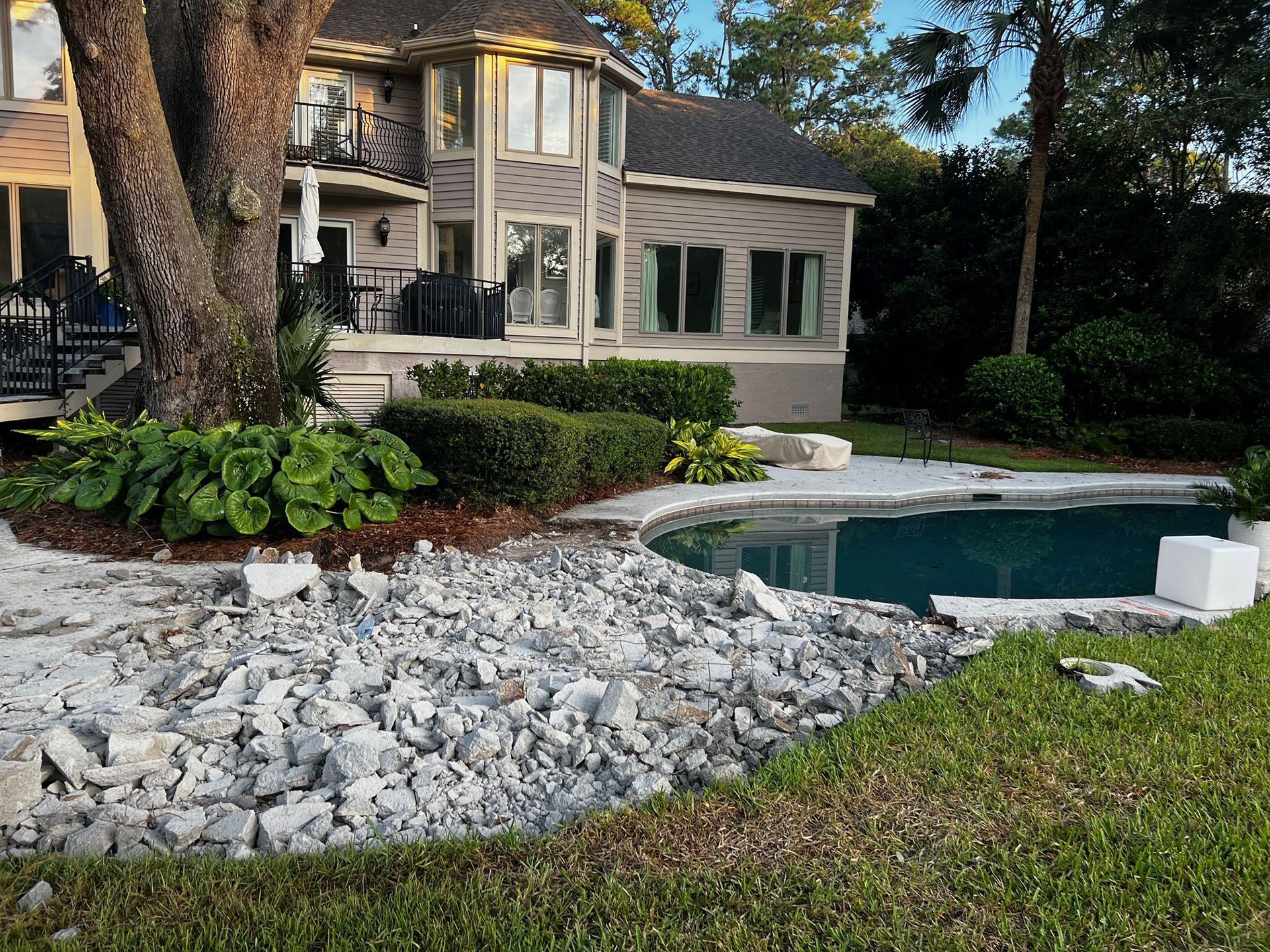 Miscellaneous Pool Projects - Construction around a pool at a two-story house, with debris and exposed ground.