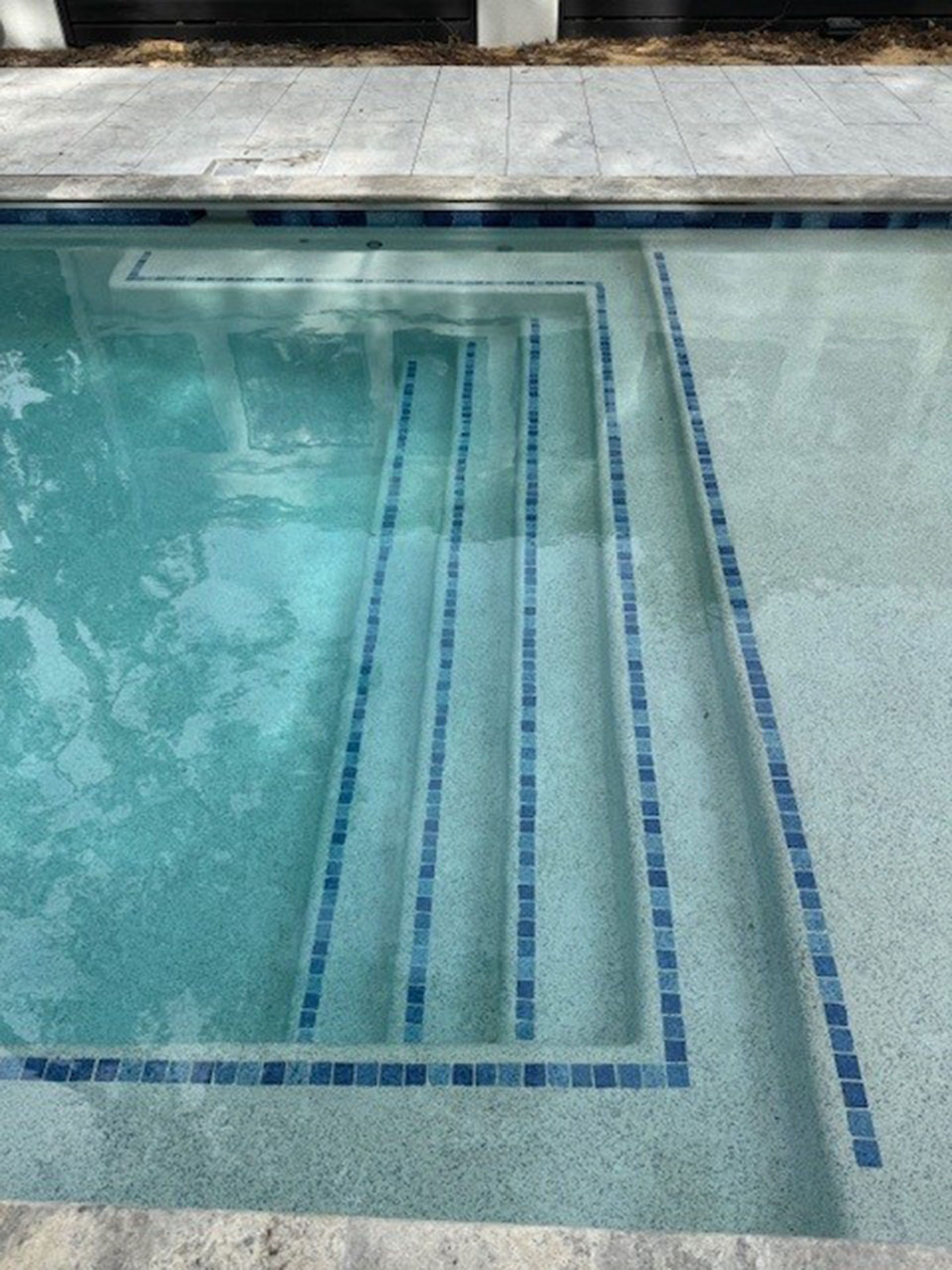 Miscellaneous Pool Projects - Pool with steps, blue tile accents, light blue water, and gray surrounding tiles.