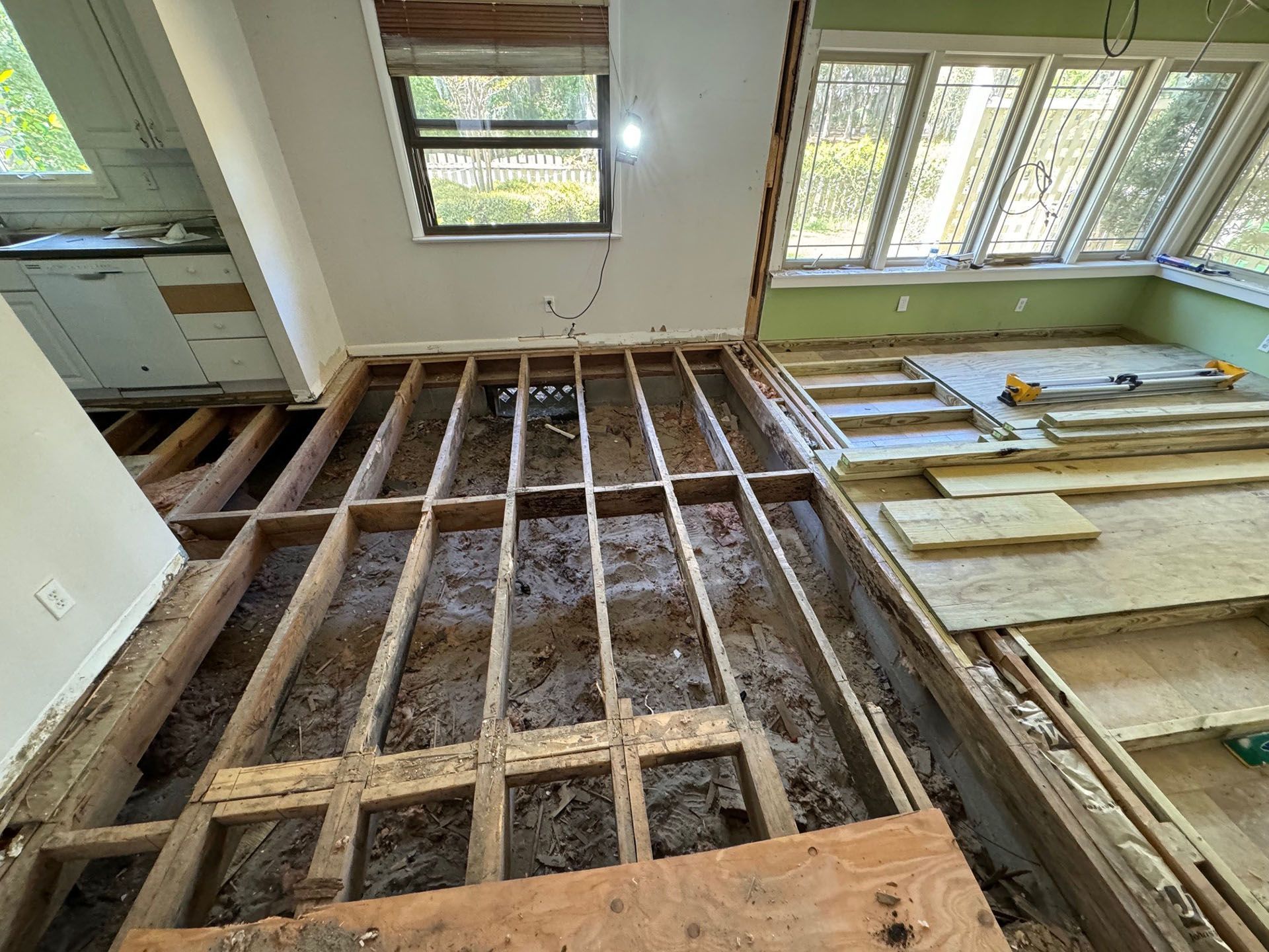 Termite Damage - Interior view of a room with exposed floor joists.  Renovation in progress.  Sunlit space with existing window and insulation.